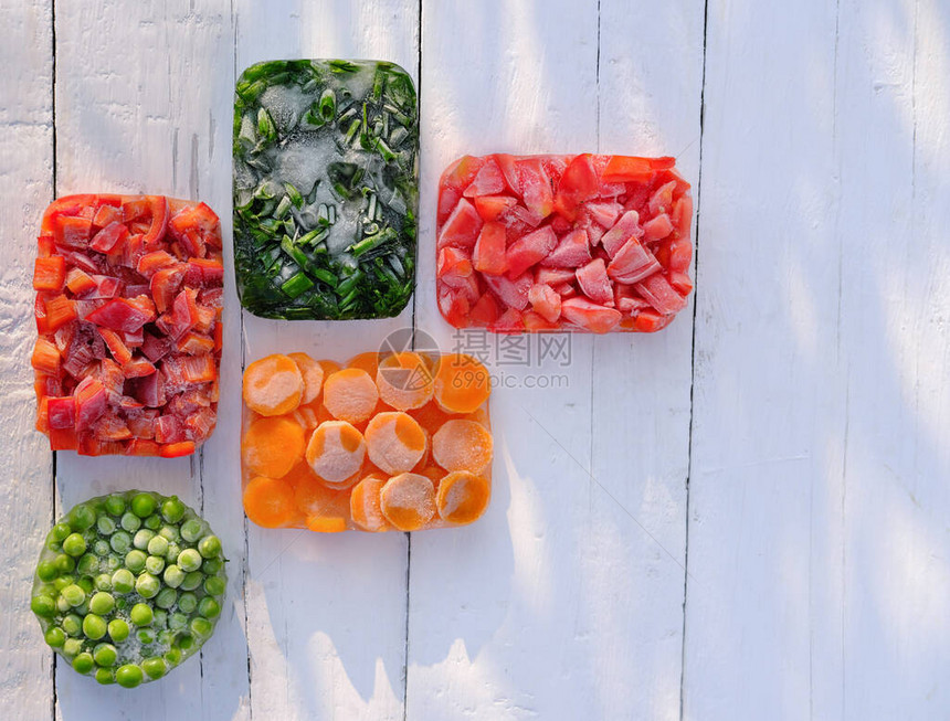在一张木桌上的几何形状的冷冻蔬菜顶视图为冬天收获和保存维生素蔬菜冷冻胡萝卜青豆洋葱和甜椒健图片