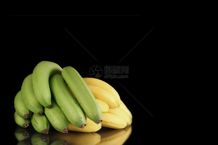 黑色背景上的绿色和黄色香蕉图片