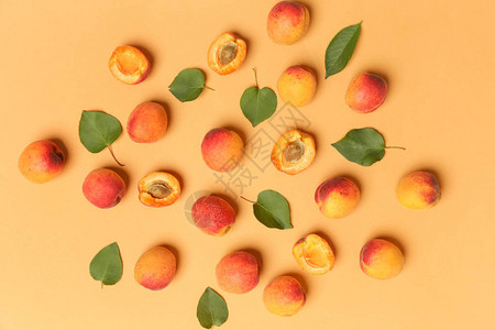 橙色背景的杏子成熟杏子和叶图片