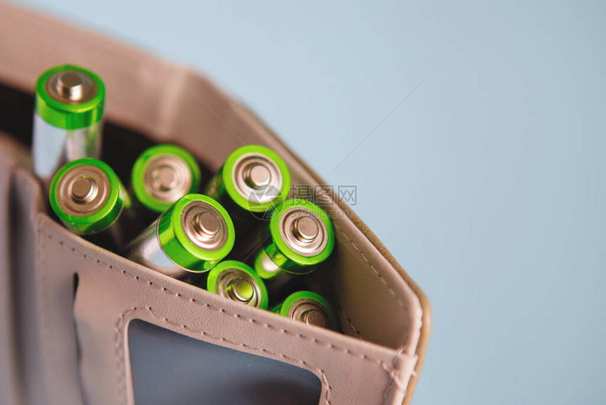 钱包中的AA碱电池保护蓝背景清洁能源符号生图片