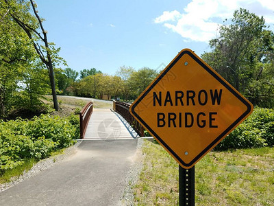 黄色狭窄的桥梁标志和沥青路背景图片