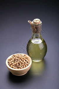 木碗里的大豆和黑色背景上的大豆油背景图片
