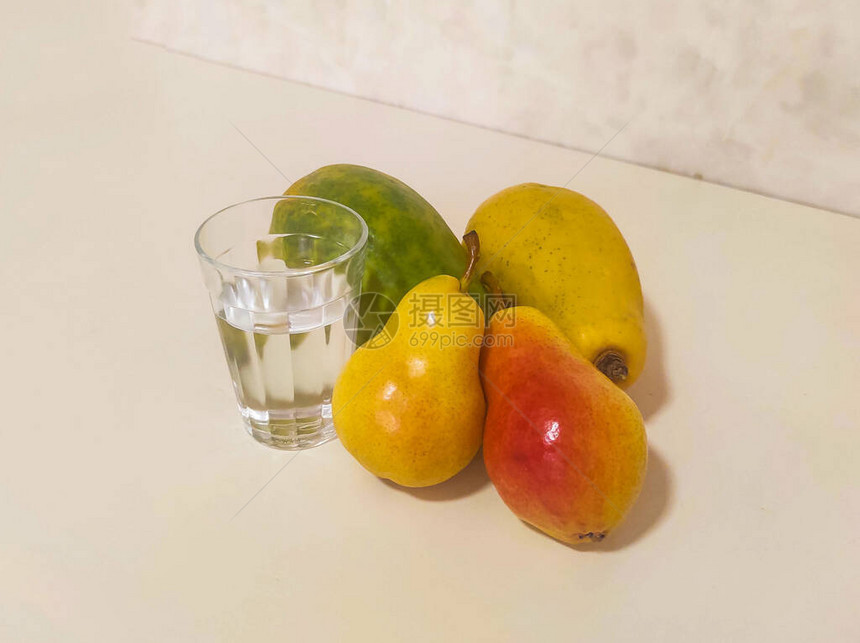 一杯水和黄水果木瓜和梨子在图片