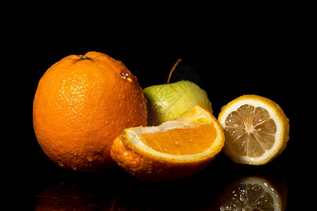 苹果和橙子水果黑色背景上滴水图片