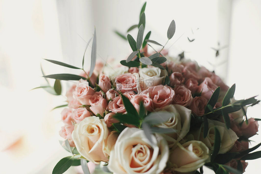 美丽的温柔的婚礼花束盛着大小粉红玫瑰清晨亮光下绿色时髦的婚图片