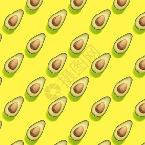 有一半鳄梨的典型黄色潮流背景食物模式图片