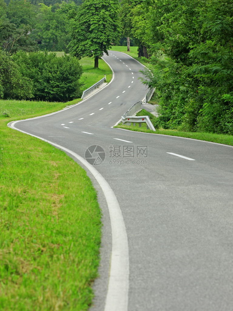 沥青蜿蜒曲折的自然道路图片