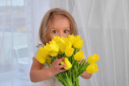 室内有黄色郁金香的小女孩图片