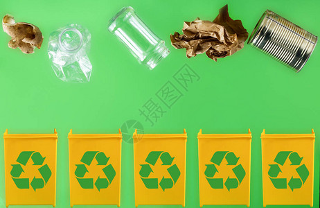 将纸金属玻璃塑料有机垃圾扔进浅绿色背景的不同黄色容器中废物分图片