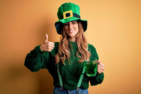漂亮的女人戴着帽子喝着绿色饮料罐庆祝圣帕特里克节图片
