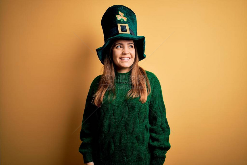 穿着绿色帽子的年轻美丽的黑发女人在圣徒节庆典上带着笑容和自然的表情图片