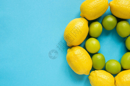在蓝底圆圈内排列的成熟黄柠檬和背景图片
