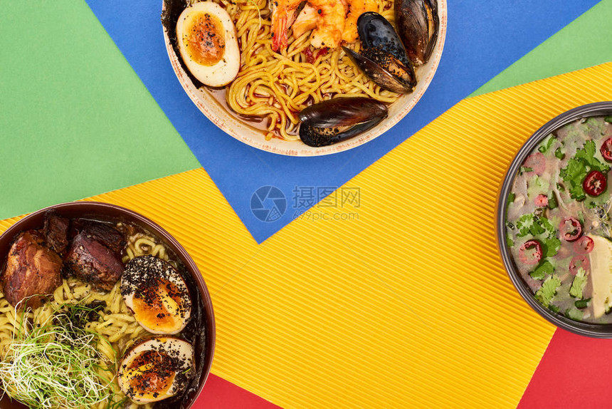 多色表面上的辣海鲜和肉拉面的顶部视图图片