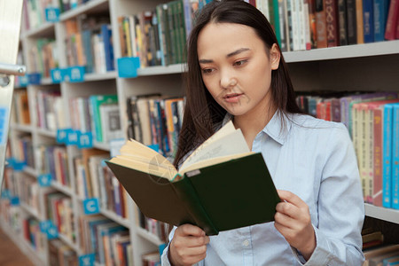 年轻的亚洲女人在图书馆看书有吸引力的女学图片