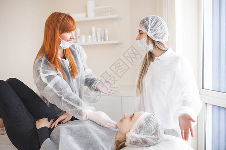 美容师教她的学生治疗病人在沙龙里和助理一起做面部照护手术图片
