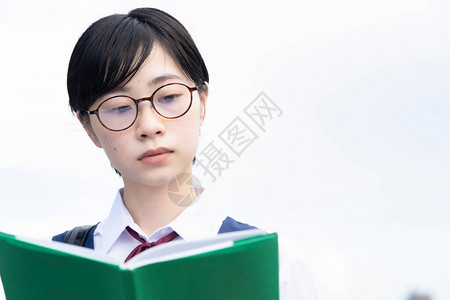 亚裔女学生用严肃的表情看书图片