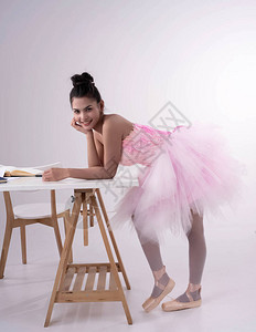 身穿粉红芭蕾西装的年轻美女面带微笑的图片