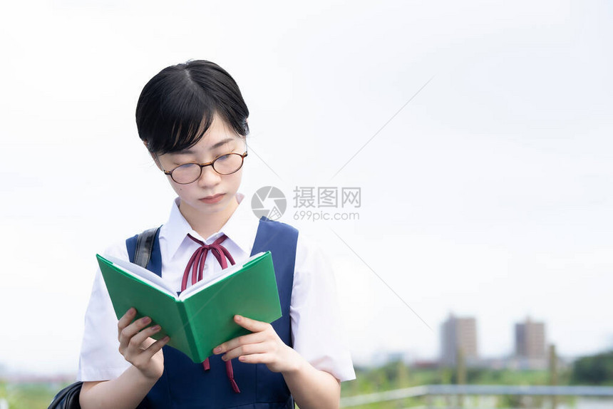 亚裔女学生用严肃的表情看书图片