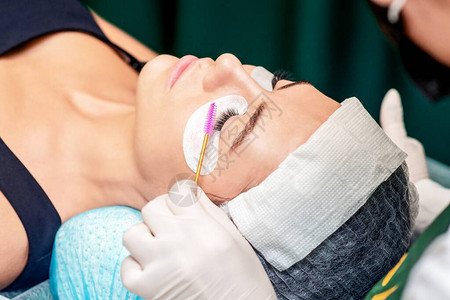美容师在美容院延长眼睫手术期间用电图片