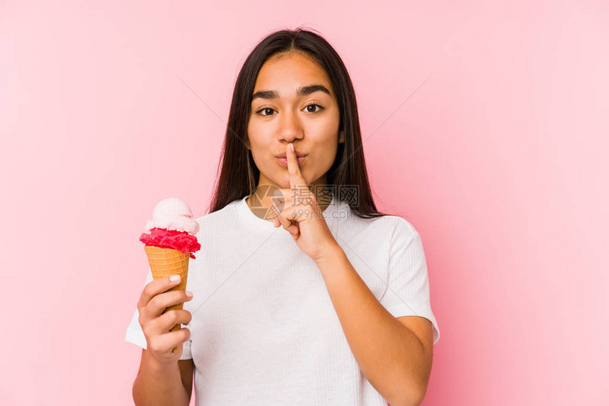 年轻的亚洲女人拿着冰淇淋孤立地保守秘密或要求保持沉默图片