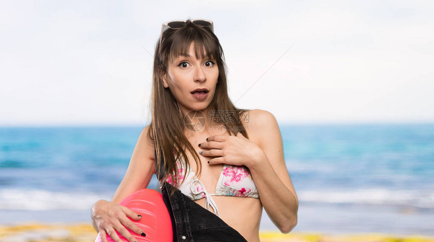 穿比基尼的年轻女子在看沙滩图片
