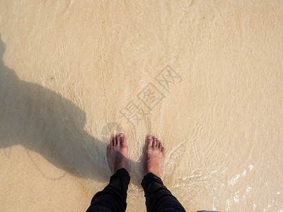 站在海滩上海浪遮盖着脚背景图片