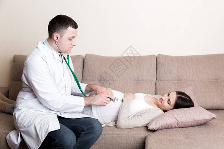 医生正在用听诊器检查孕妇的腹部图片