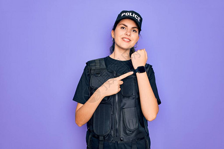 身穿紫色背景安全防弹背心制服的年轻女警急忙指着时间高清图片