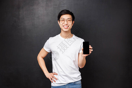 年轻男店员的肖像展示智能手机的新功能图片