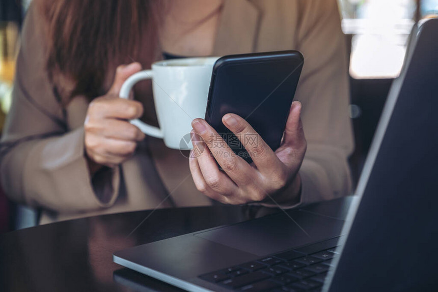 一位女在咖啡厅喝咖啡用笔记本电脑工作时图片