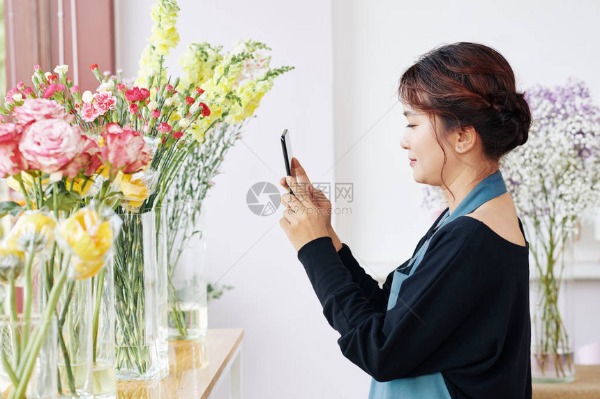 年轻亚洲花卉家为社交媒体或网上商店拍摄花瓶中美丽图片