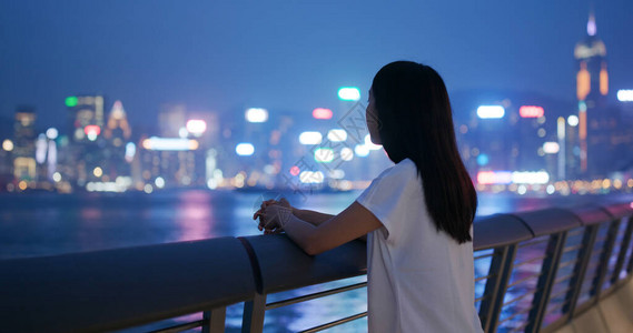 女人在晚上看城市景观图片