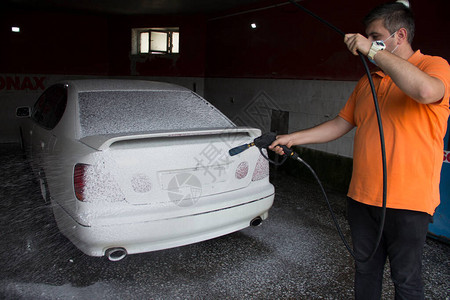 年轻人在洗车时用泡图片