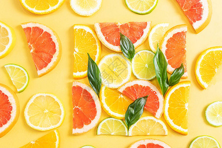 橙子柠檬葡萄柚和酸橙被切成方形并铺开明亮的夏天背景水果图像新鲜水果维生素食品背景图片