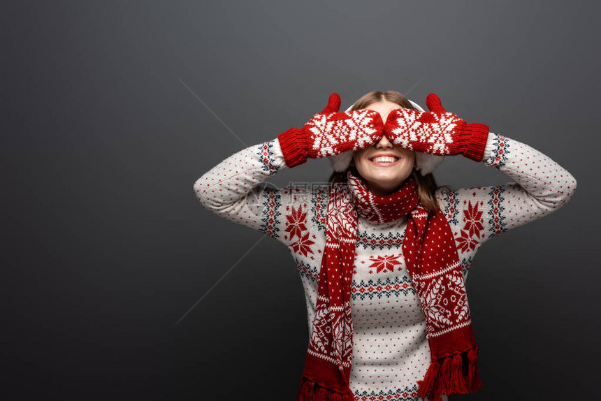 穿着圣诞毛衣围巾手套和耳膜的快乐妇女闭着眼睛图片