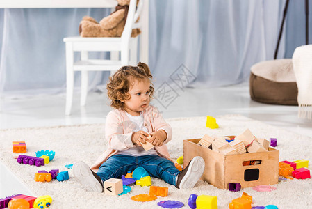 可爱的小孩坐在地毯上玩具图片