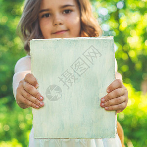 可爱勤劳的孩子在户外站着一本书和一个公文包看书的小女孩图片