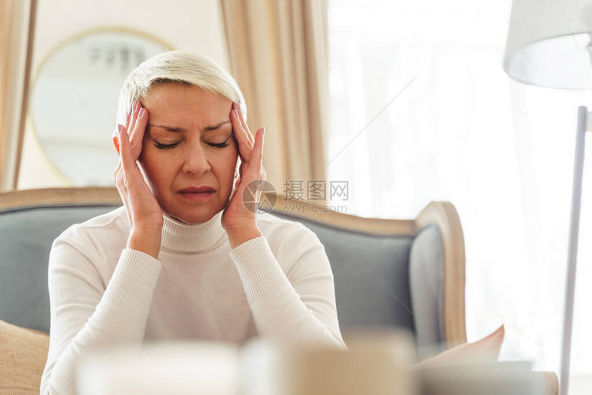 一位情绪低落不快乐的白种妇女短头发高龄长发严重头痛的Wais图片