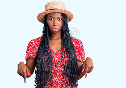 戴着夏帽的年轻非洲裔美国妇女低头看着悲伤和不安图片