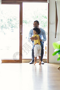 幸福的家庭非洲裔美国儿子从办公室回来后跑步和拥抱爸欢迎回家爸和父亲概图片