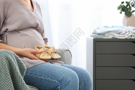 孕妇在家里穿婴儿鞋特写图片