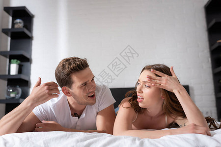 一对不开心的情侣看着对方躺在床图片