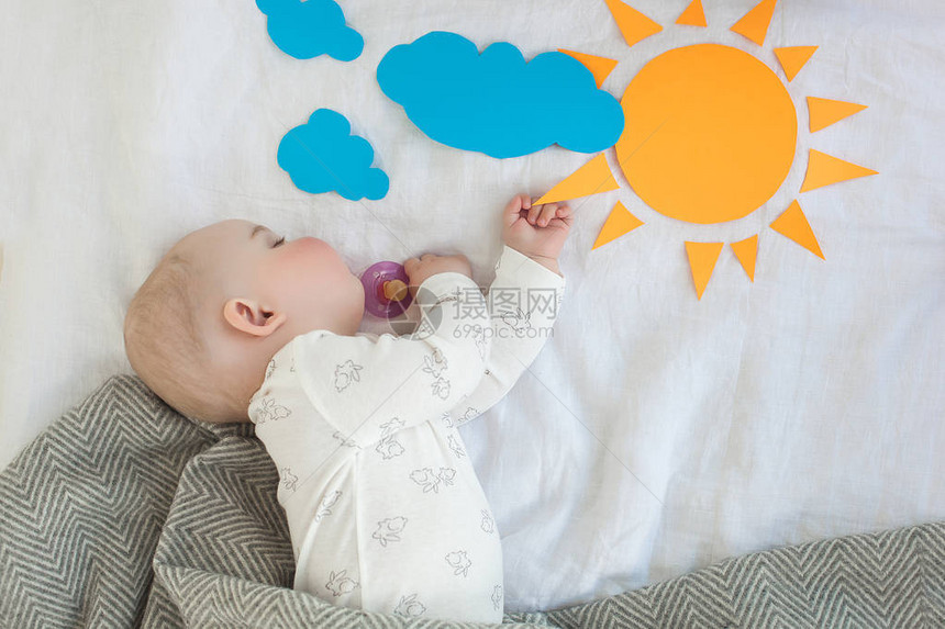 早上睡在床上的婴儿起床时间到了早晨的阳光一个困倦的婴儿图片
