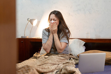 床上的女人想在重度流感期间完成她的任务图片
