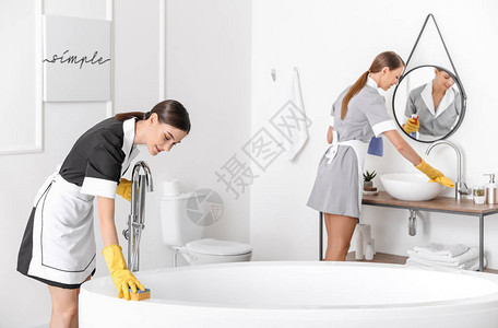 美丽的女服务员打扫酒店浴室图片