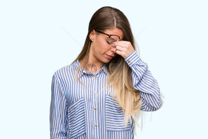 美丽的年轻女子穿着优雅的衬衫和眼镜累了揉鼻子和眼睛感到疲劳和头痛压力图片