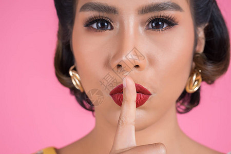 美丽的亚洲女人红唇和手指显示安静的沉默标志图片