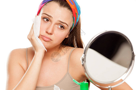 疲累和悲伤的年轻女人在白色背景的镜子图片