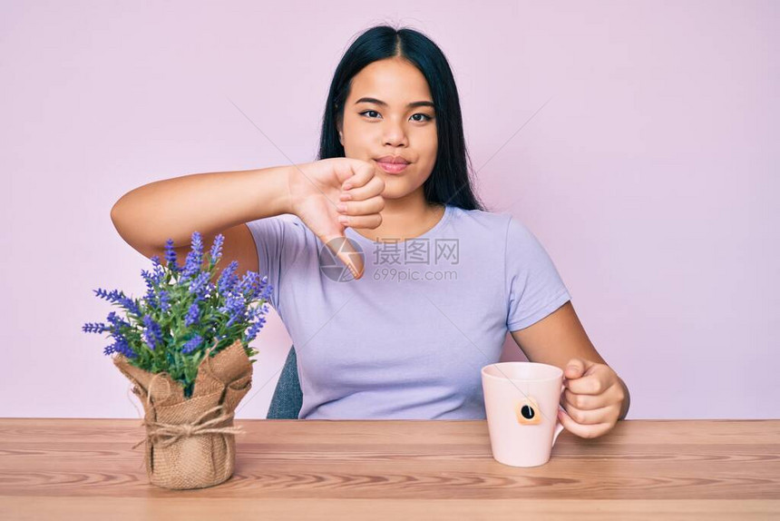 年轻漂亮的亚洲女孩喝着一杯浸泡过的薰衣草图片