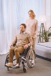 丈夫坐在轮椅上妻子在卧图片